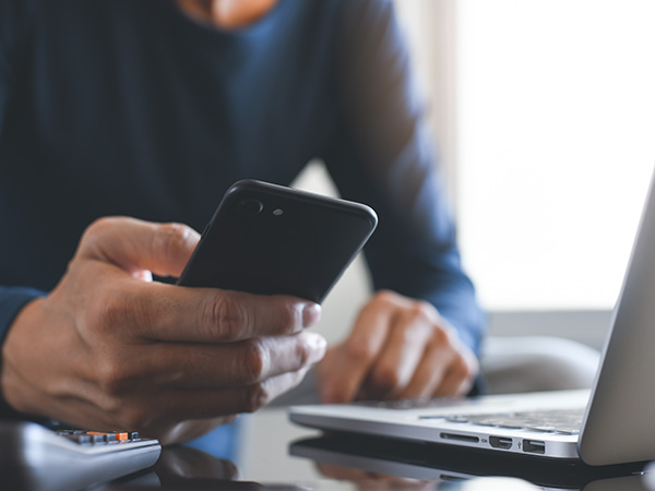 Mann wählt Rufnummer auf seinem Smartphone